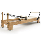 Pilates Reformer Studio Classic, telaio in rovere, rivestimento bianco latte – vista 3/4