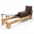 Pilates Reformer Studio Classic, telaio in rovere, rivestimento moka – con sitting box e jumpboard