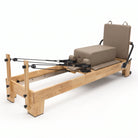 Pilates Reformer Studio Classic, telaio in rovere, rivestimento tortora – con sitting box e jumpboard