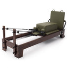 Pilates Reformer Studio Prestige, rovere finitura noce, rivestimento oliva – con sitting box e jumpboard