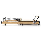 Reformer Pilates pieghevole Flexi, legno naturale, rivestimento bianco latte – vista laterale