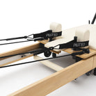 Reformer Pilates pieghevole Flexi, legno naturale, rivestimento bianco latte – carrello con poggiaspalle