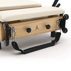Reformer Pilates pieghevole Flexi, legno naturale, rivestimento bianco latte – maniglie e ruote