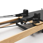 Reformer Pilates pieghevole Flexi, legno naturale, rivestimento nero – carrello con poggiaspalle